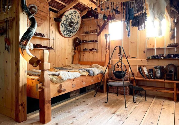 a bedroom with wooden walls and flooring has many items hanging on the wall, including a bed