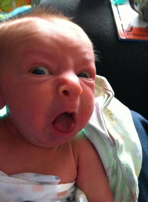 a baby with its mouth wide open in front of a sign that says otan baeniez