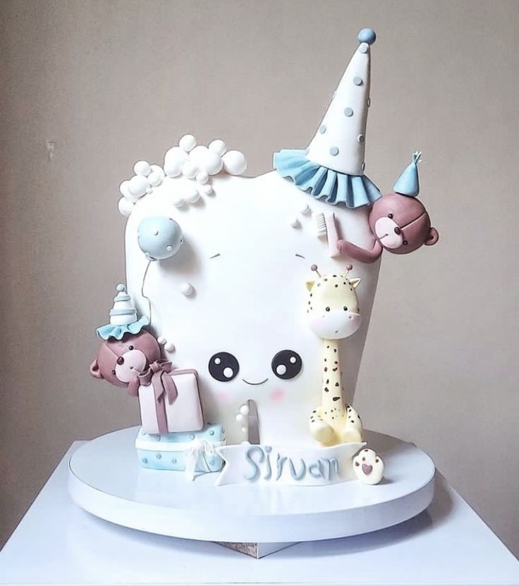 a white cake decorated with animals and balloons