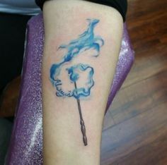 a woman's leg with a blue tattoo on it and an umbrella in the shape of a horse