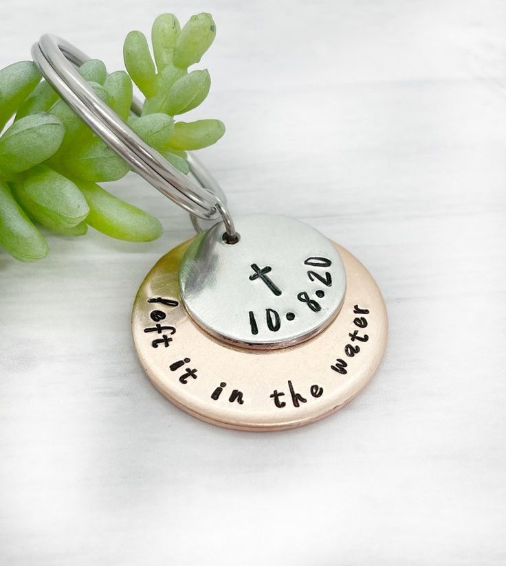 three personalized metal discs with the names of two people on them and one is holding a plant