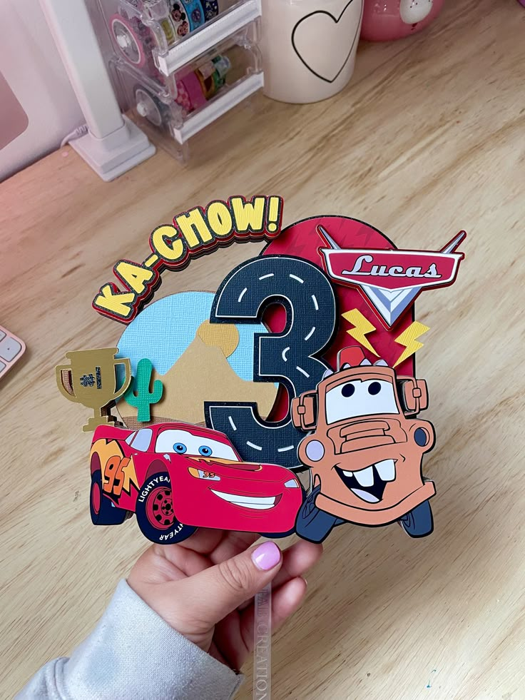 a person holding up a sticker with cars on it