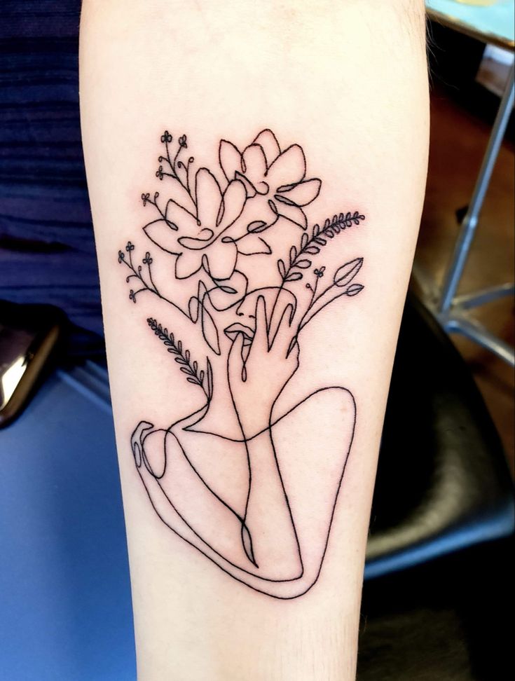 a woman's arm with flowers on it