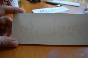 a person is holding up a sign that says flustery on it in front of a desk