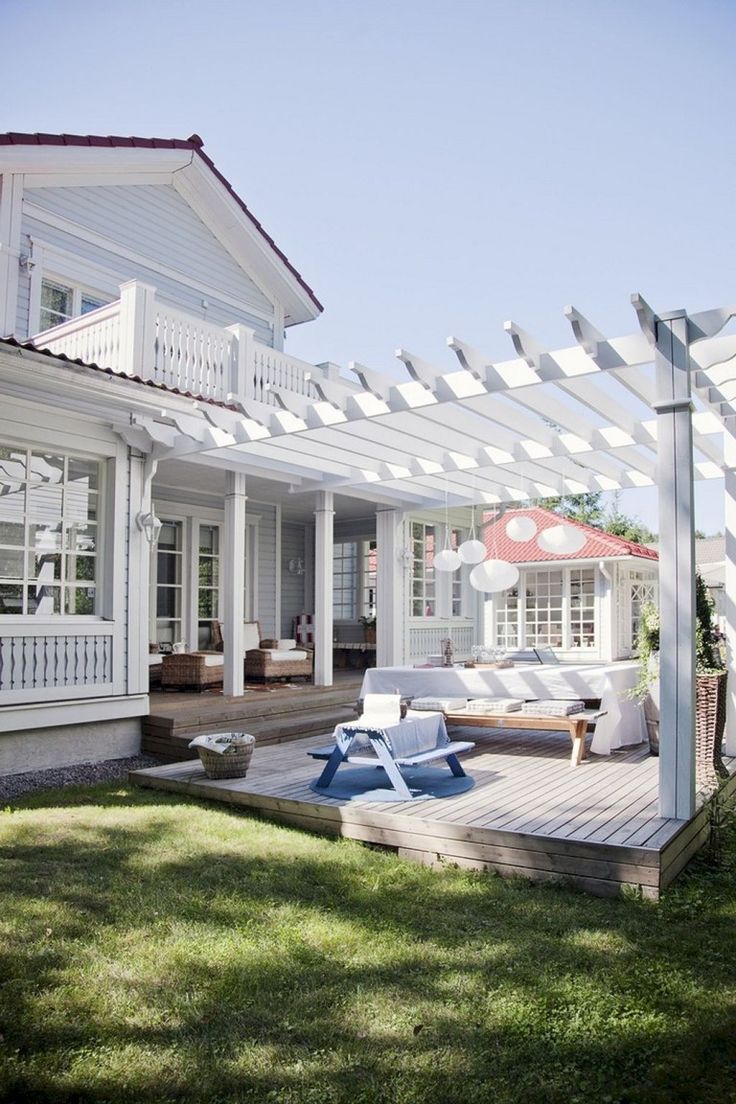 an outdoor living area with white furniture and pergolated awnings on the roof