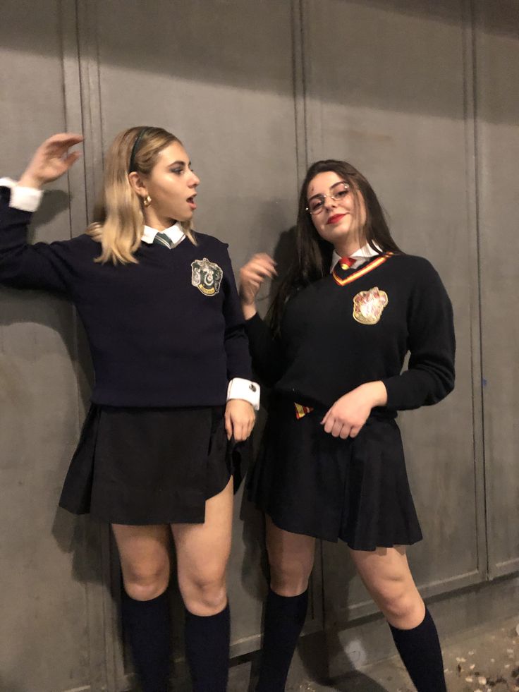 two women dressed in school uniforms posing for the camera