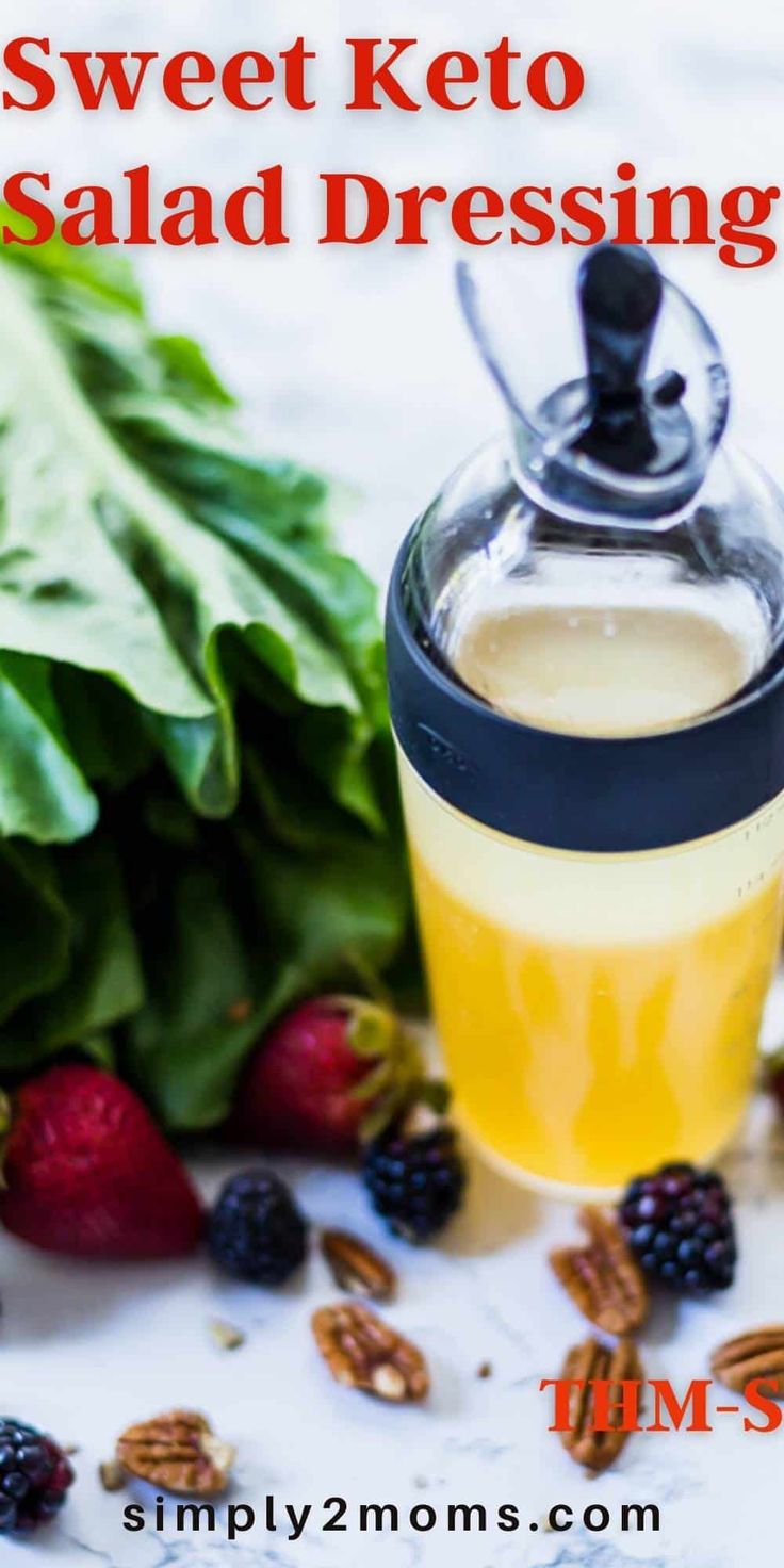 a glass jar filled with liquid next to berries and spinach