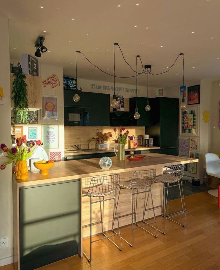 a kitchen with an island and chairs in the center, surrounded by wood floorsing