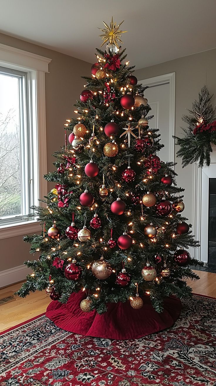 a decorated christmas tree in a living room with red and gold ornaments on the top