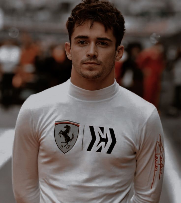 a man wearing a white shirt with a ferrari logo on it