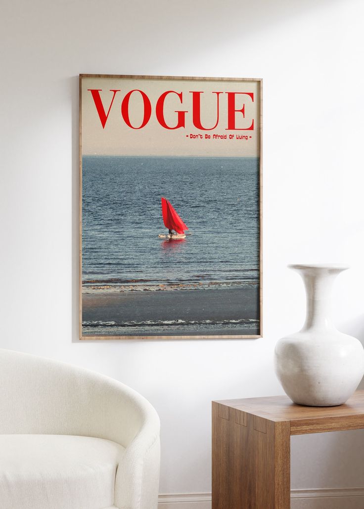 a magazine cover with a red sailboat on the water in front of a white chair