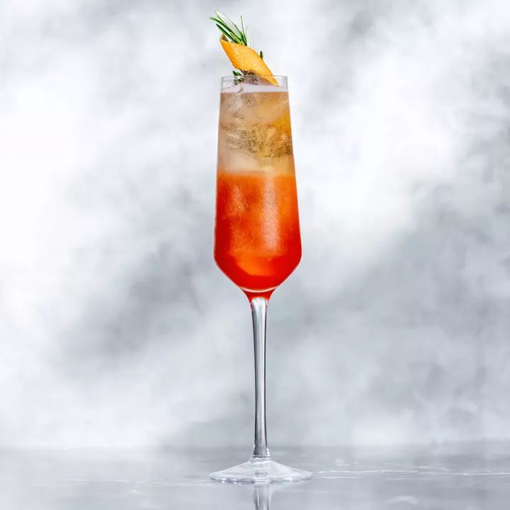 a tall glass filled with a drink and garnished with an orange slice on top