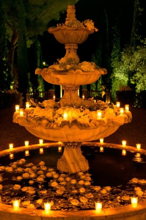 a fountain with lit candles in the middle