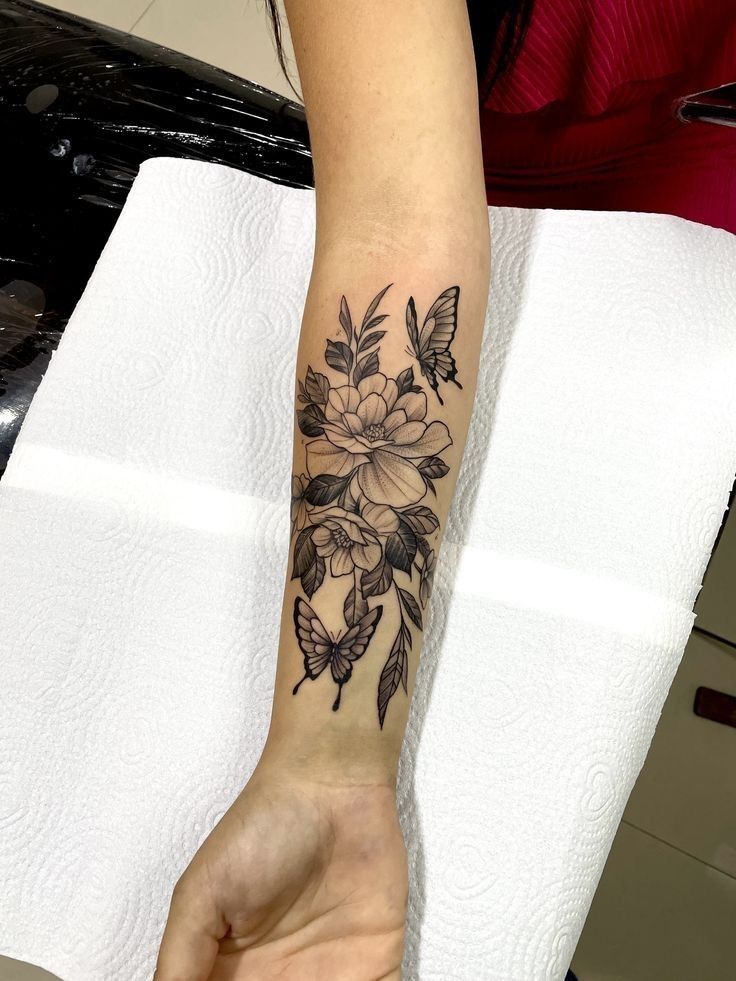 a woman's arm with a flower tattoo on it