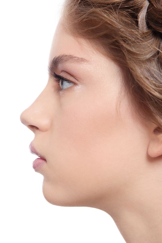 a woman's profile is shown with her hair in a bun and earrings on