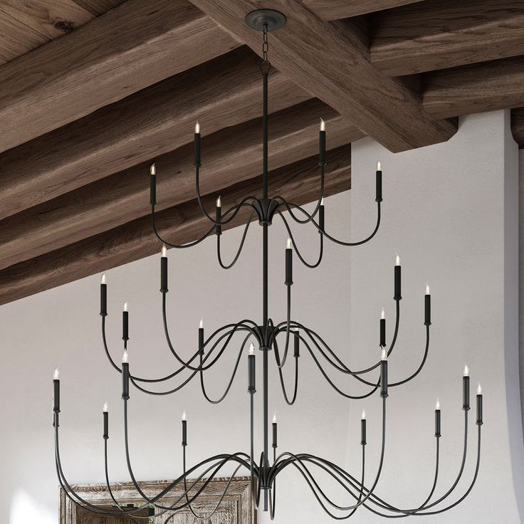 a chandelier hanging from the ceiling in a room with white walls and wood beams