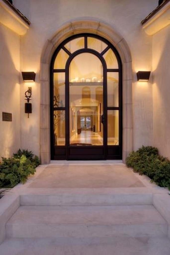 an entry way with steps leading up to the door and lights on either side of it