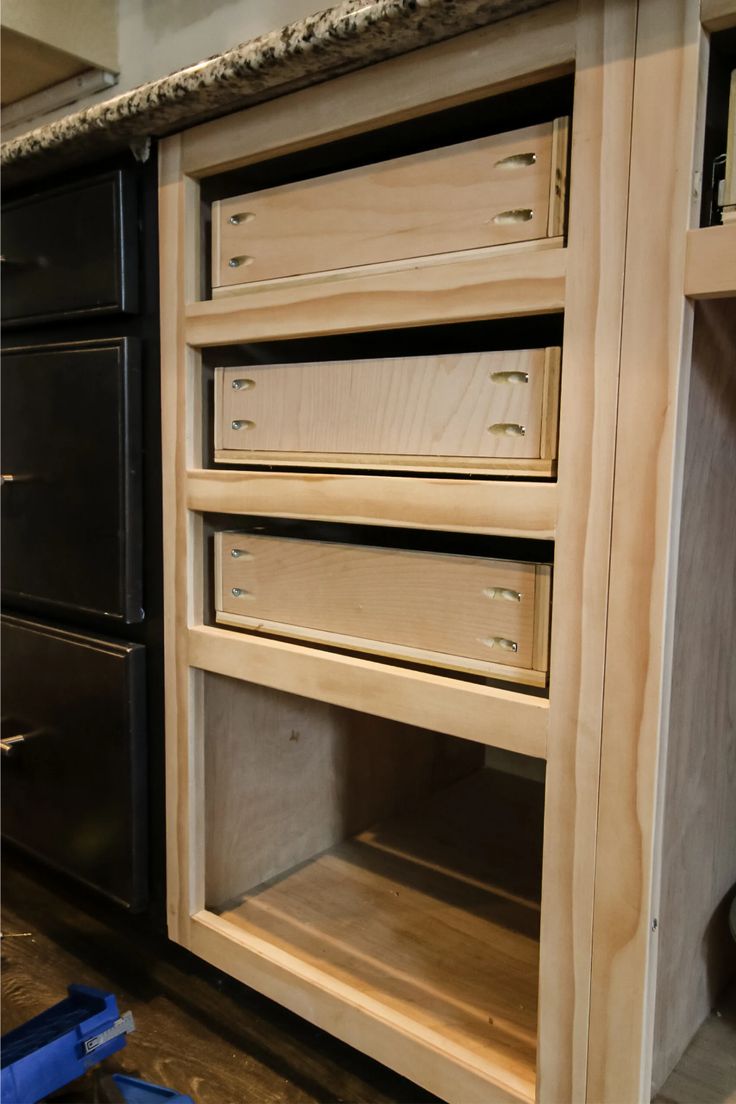 an unfinished kitchen cabinet with drawers in it