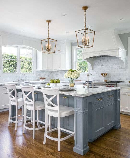 a kitchen with white cabinets and blue island