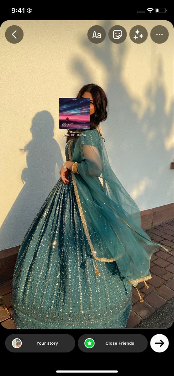 a woman in a blue dress is walking down the street with a laptop on her head