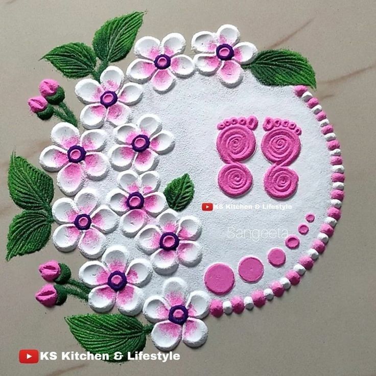 a close up of a cake decorated with flowers and baby's feet on it