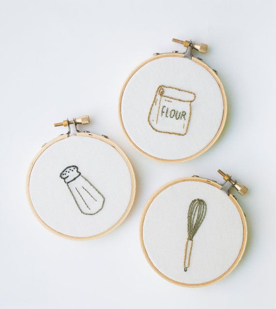 three embroidery hoop frames with embroidered images of flour, whisk and kitchen utensils