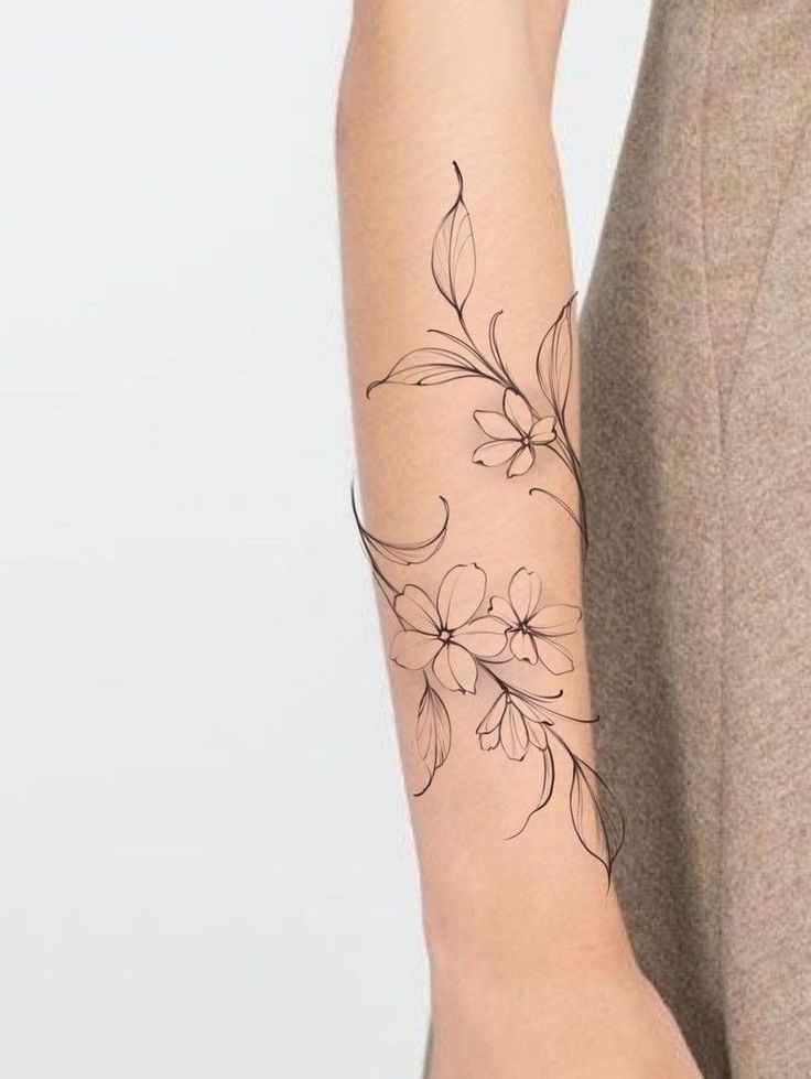 a woman's arm with a flower tattoo on the left side of her arm