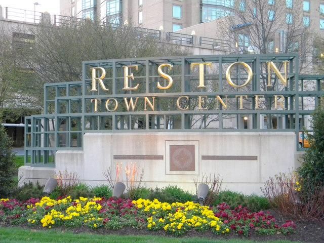 there is a sign that says reston town center in front of flowers and trees