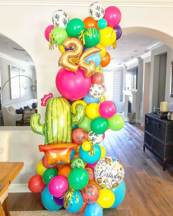 a large balloon column in the middle of a living room filled with balloons and decorations