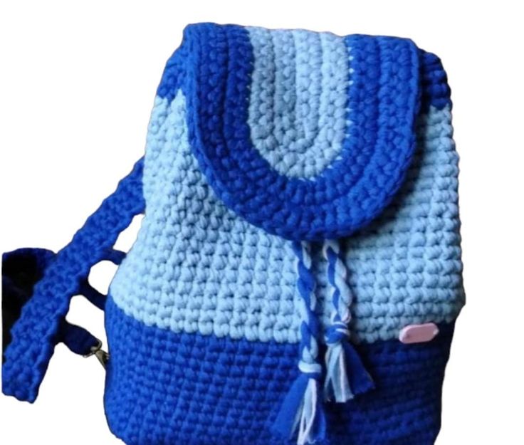 a crocheted blue and white purse with tassels on the front pocket