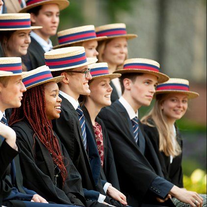 a group of people sitting next to each other in suits and ties wearing matching hats