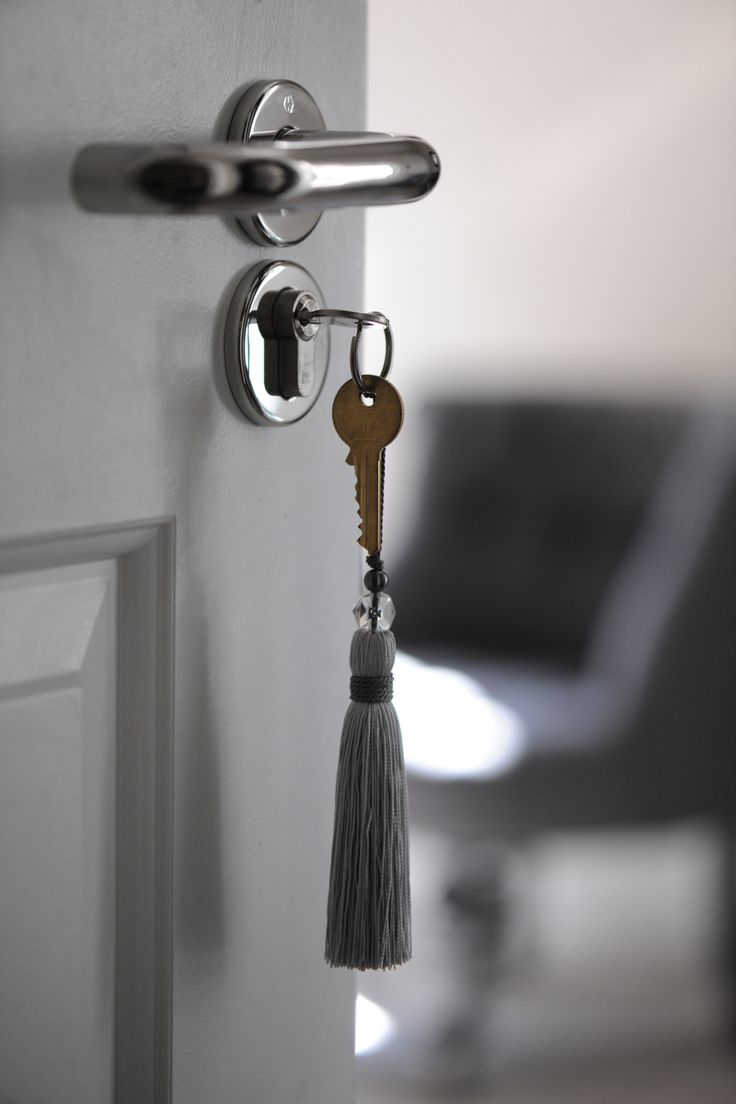 a door handle with a tassel hanging from it's side next to a chair