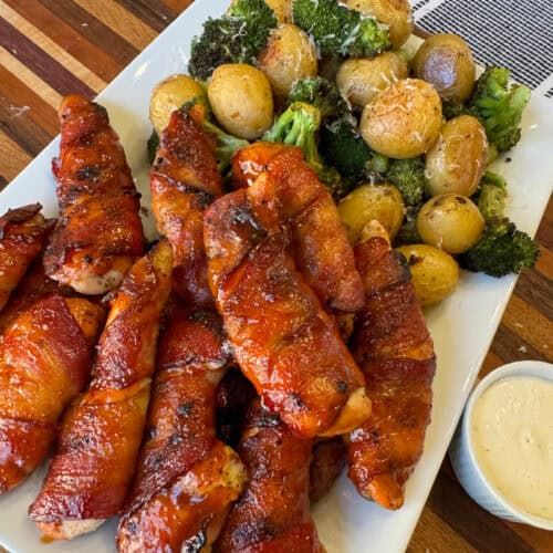 chicken wings, potatoes and broccoli on a white plate with dipping sauces