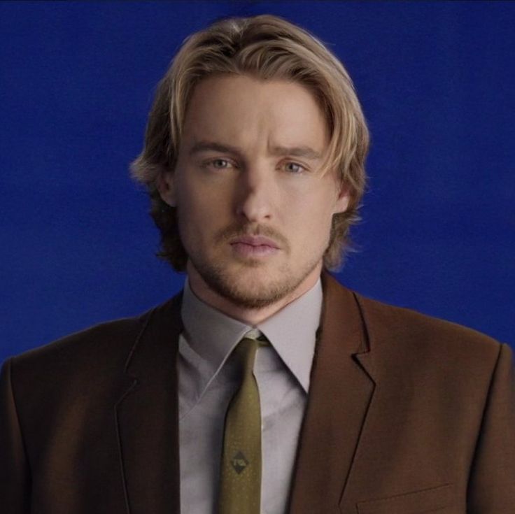 a man in a suit and tie looking at the camera with a serious look on his face