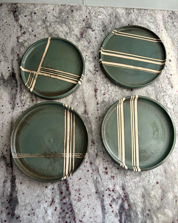 three green plates sitting on top of a marble counter