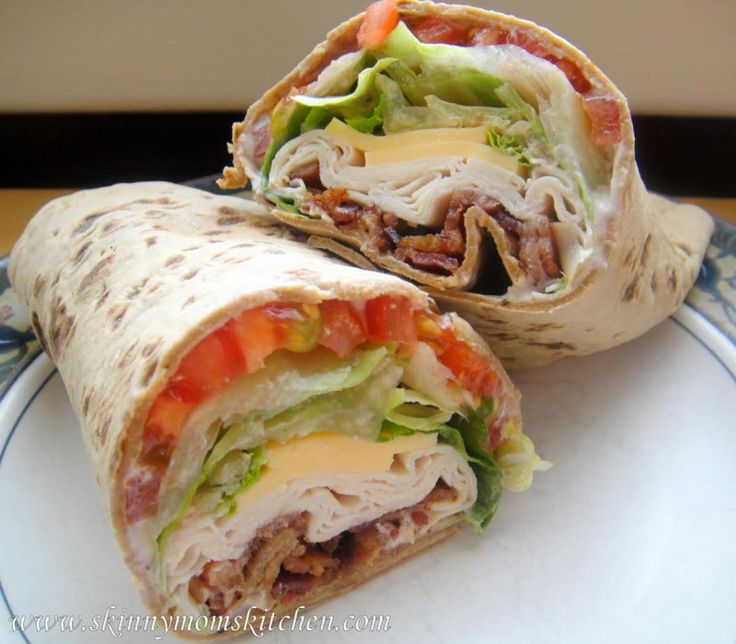 two burritos with meat, cheese and vegetables on them sitting on a plate