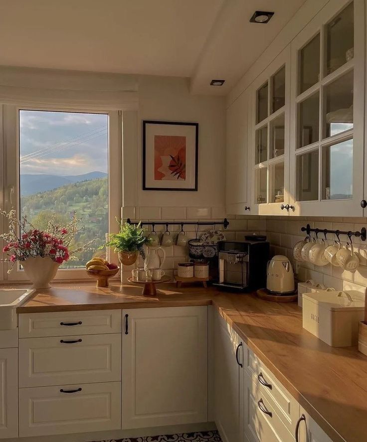 a kitchen filled with lots of counter top space next to a large window overlooking the mountains