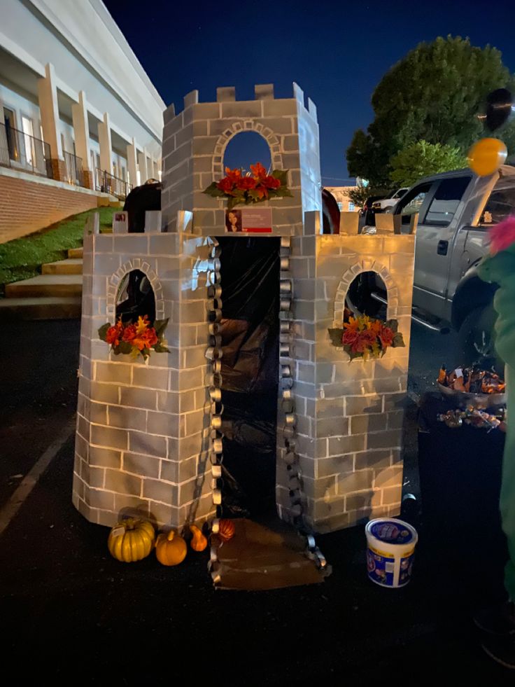 a castle made out of plastic sitting on top of a parking lot next to a building