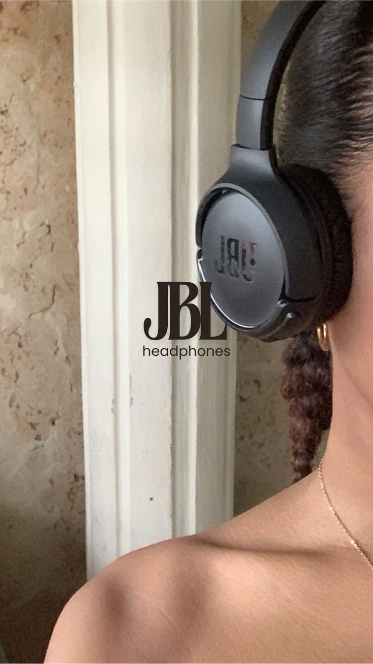 a close up of a person wearing headphones near a door with a wall in the background