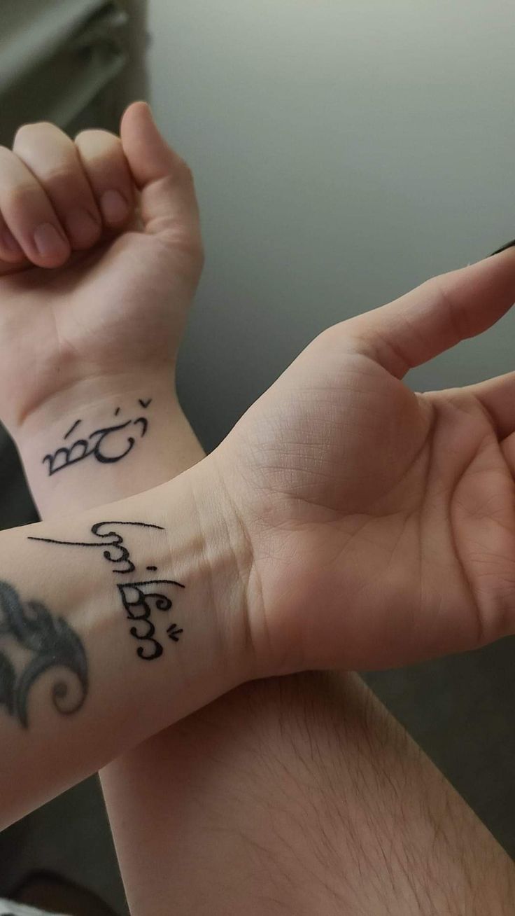 two people with tattoos on their arms and wrist