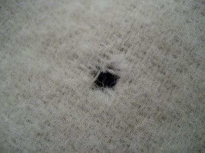 a black hole in the middle of a white blanket