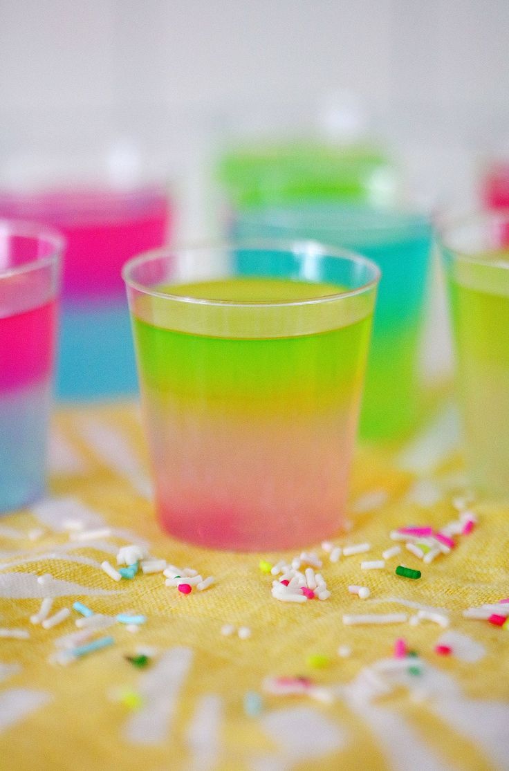 colorful cups with sprinkles and confetti on a yellow tablecloth