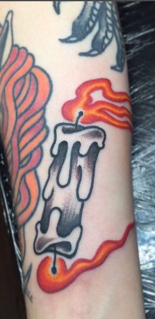 a tattoo on the arm of a person with an orange and black flame behind it