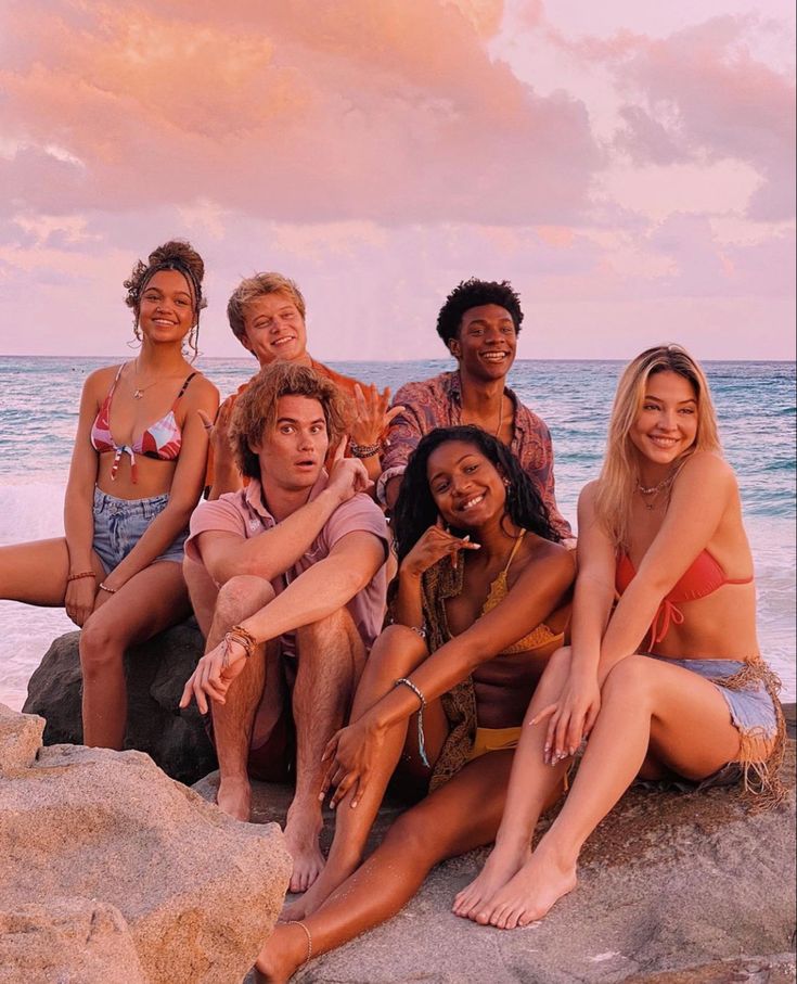 a group of young women sitting on top of a boat next to each other in bikinis