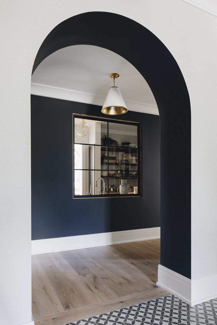 an archway in a room with blue walls and white trim on the wall, along with a black and white checkered floor