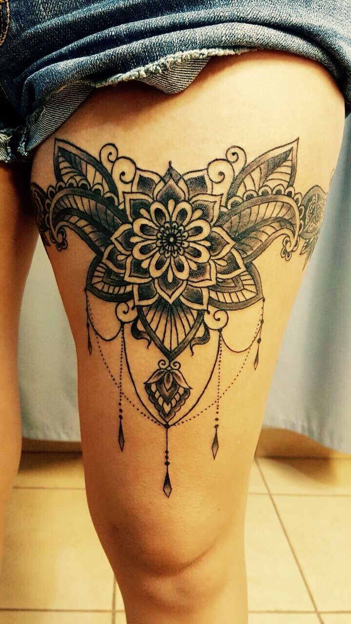 a woman's thigh with an intricate tattoo on it