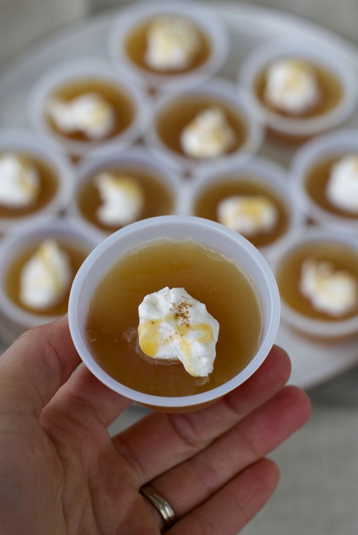 a hand holding a small cup filled with liquid