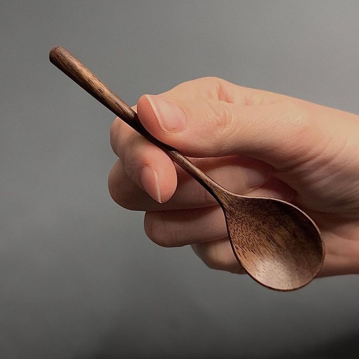 a person holding a wooden spoon in their hand