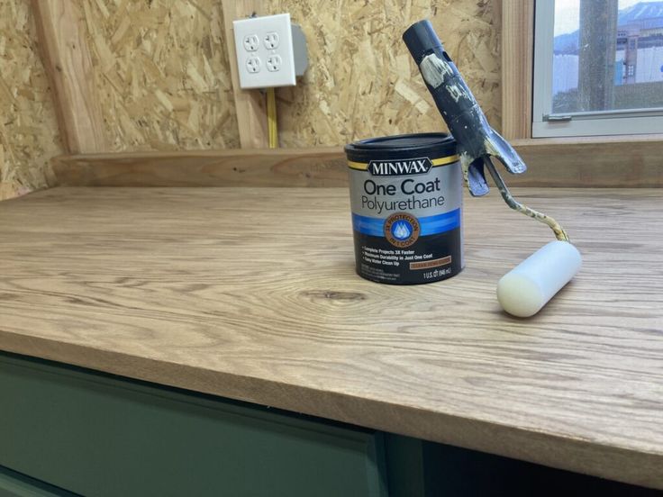 a can of paint sitting on top of a wooden counter