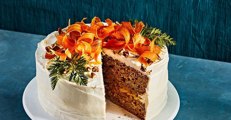 a cake with white frosting and orange flowers on top is cut in half to show the inside